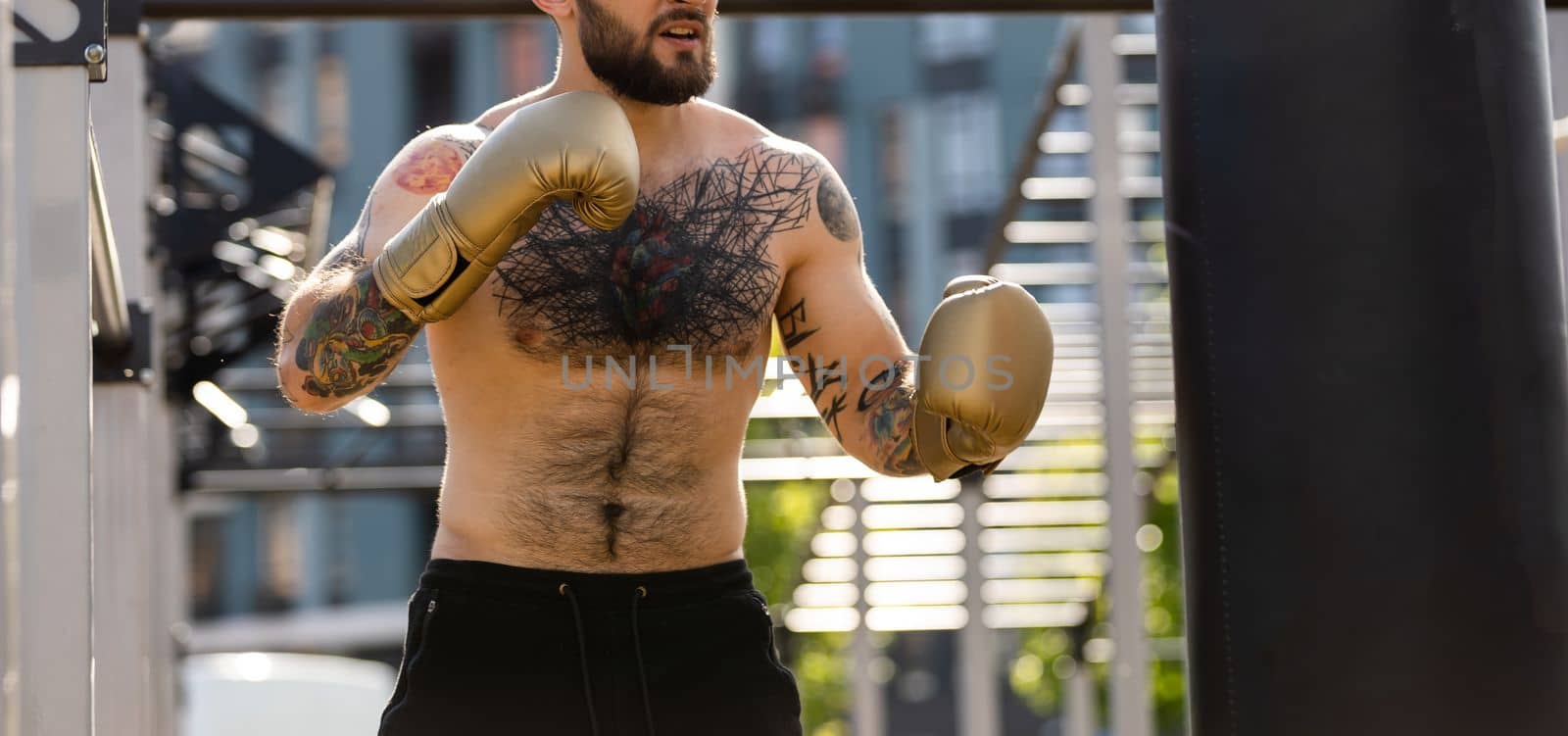 Man in boxing gloves is practicing on an outdoor.