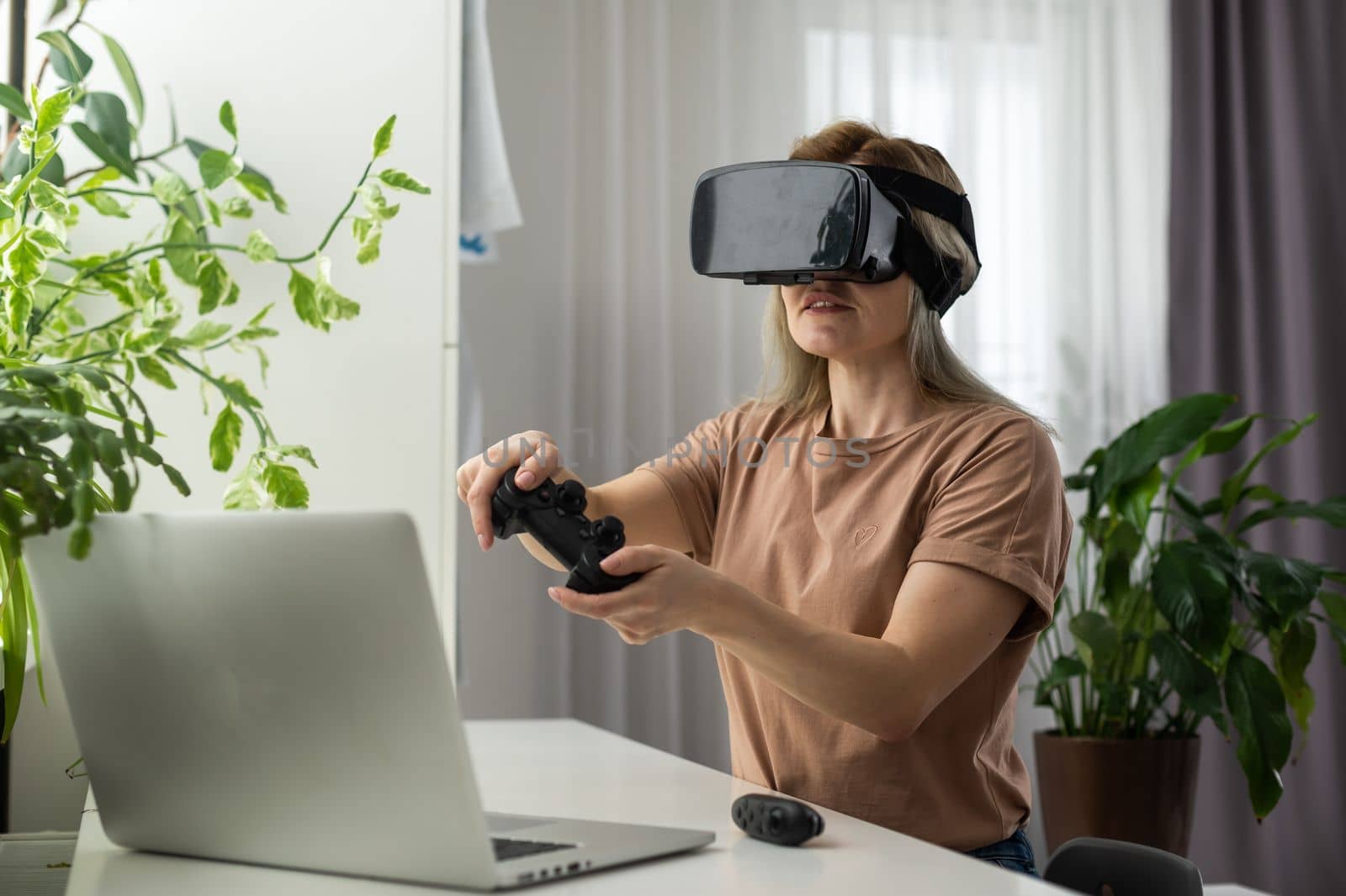 Woman in VR headset looking up at the objects in virtual reality. VR is a computer technology that simulates a physical presence and allows the user to interact with environment by Andelov13