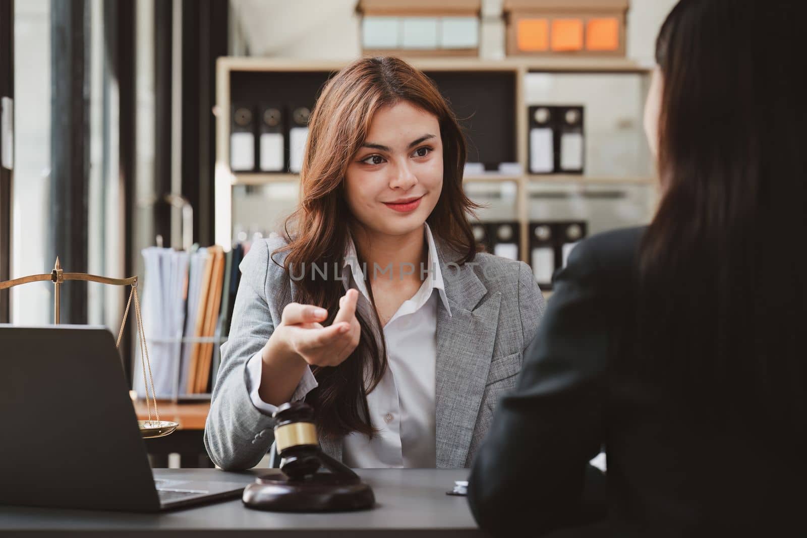 Business woman and lawyers discussing contract papers with brass scale on wooden desk in office. Law, legal services, advice, Justice and real estate concept by itchaznong