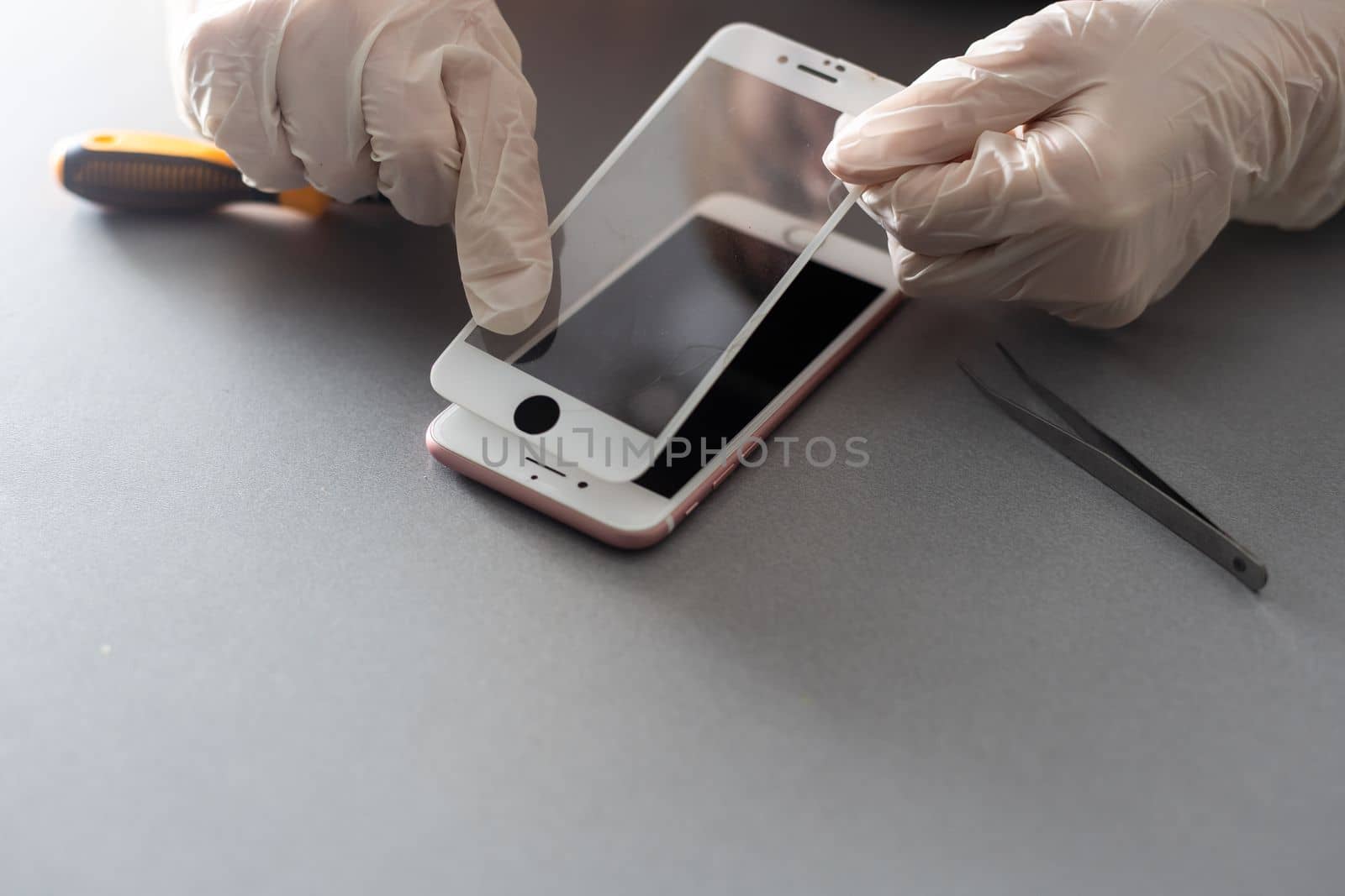 a person places a protective glass or film on a smartphone. copy space