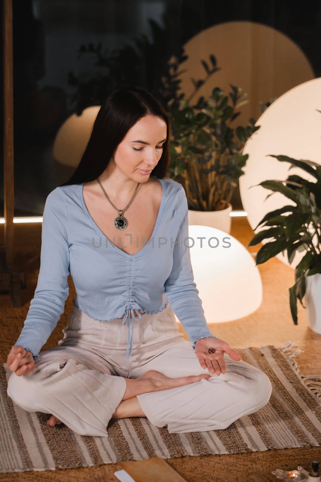 A young woman sitting in the Lotus position before the Game was playing and holding game cubes in her hand by Lobachad