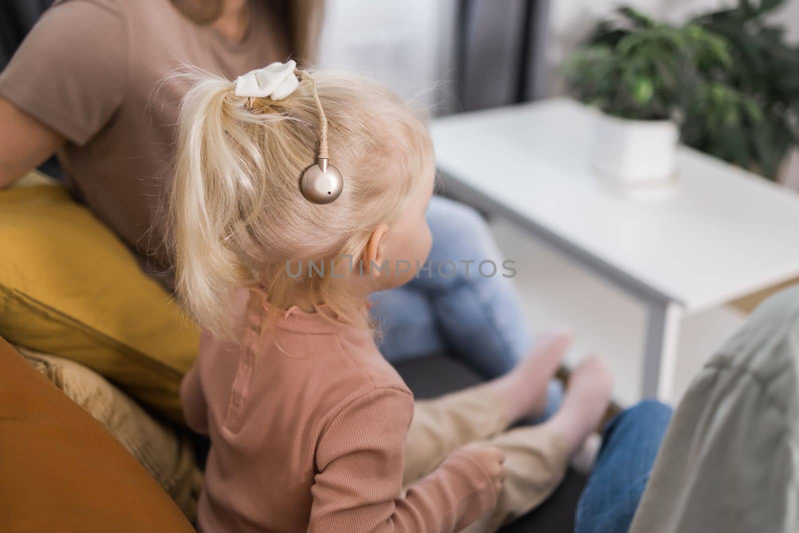 Cochlear implant system. Installation cochlear implant on child girl ear for restores hearing. Kid hears after hear return to normal.