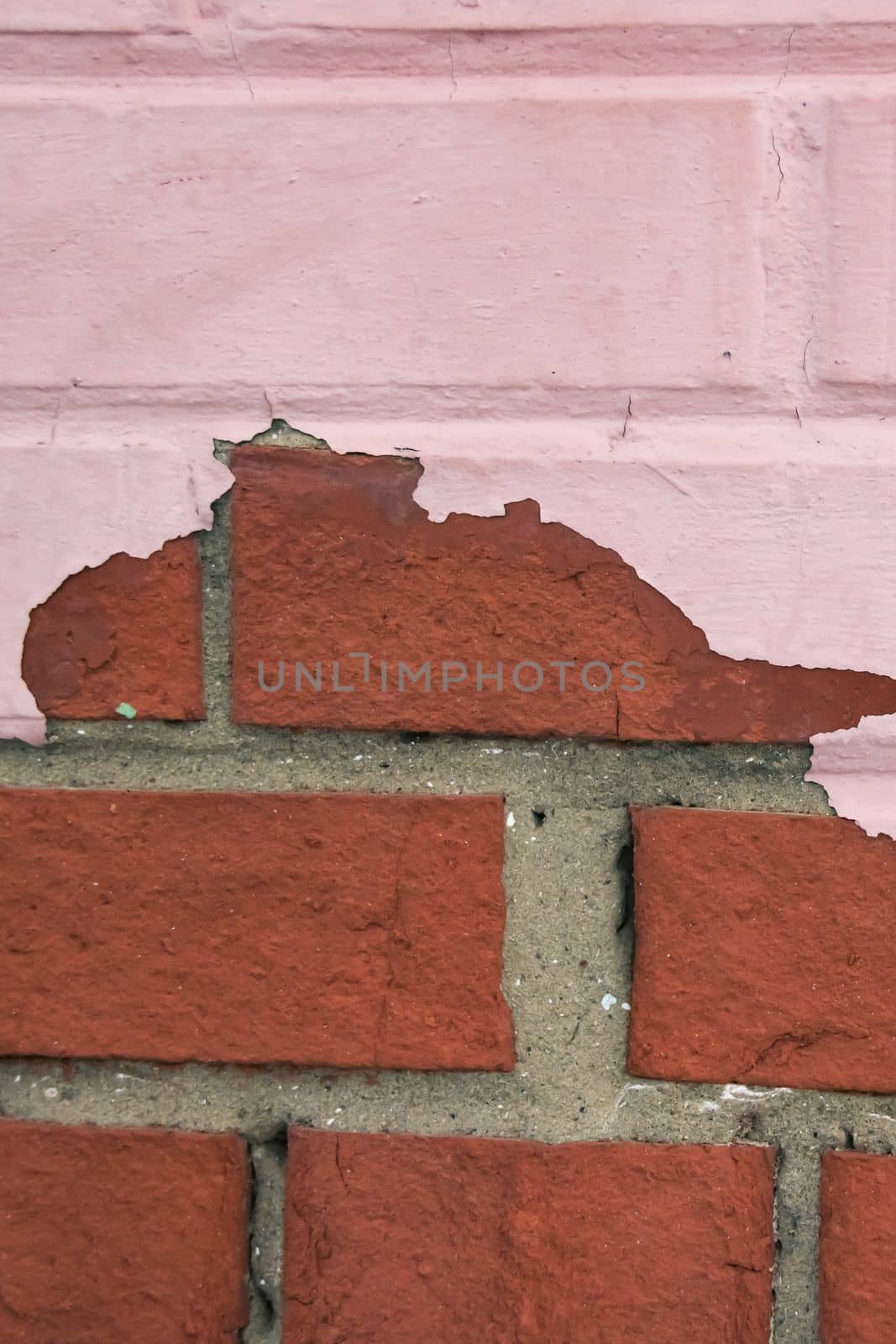 Peeling red paint on a brick wall, background or texture