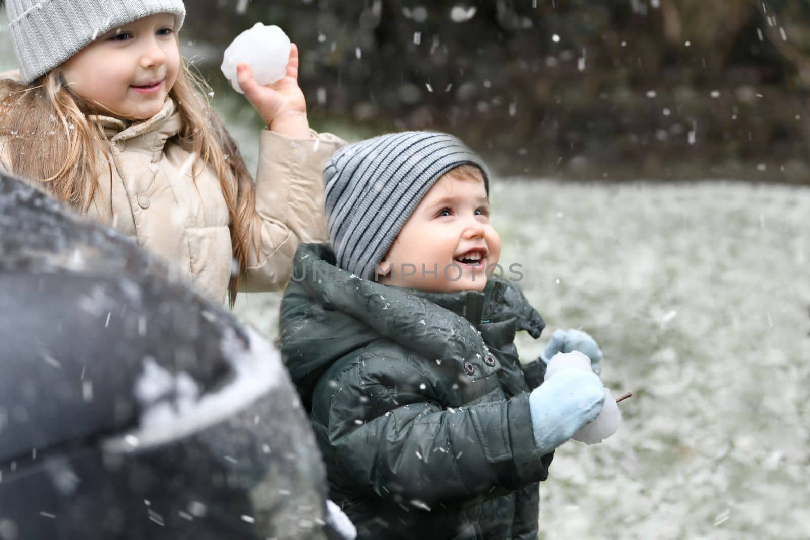 The kids playing snowballs outside