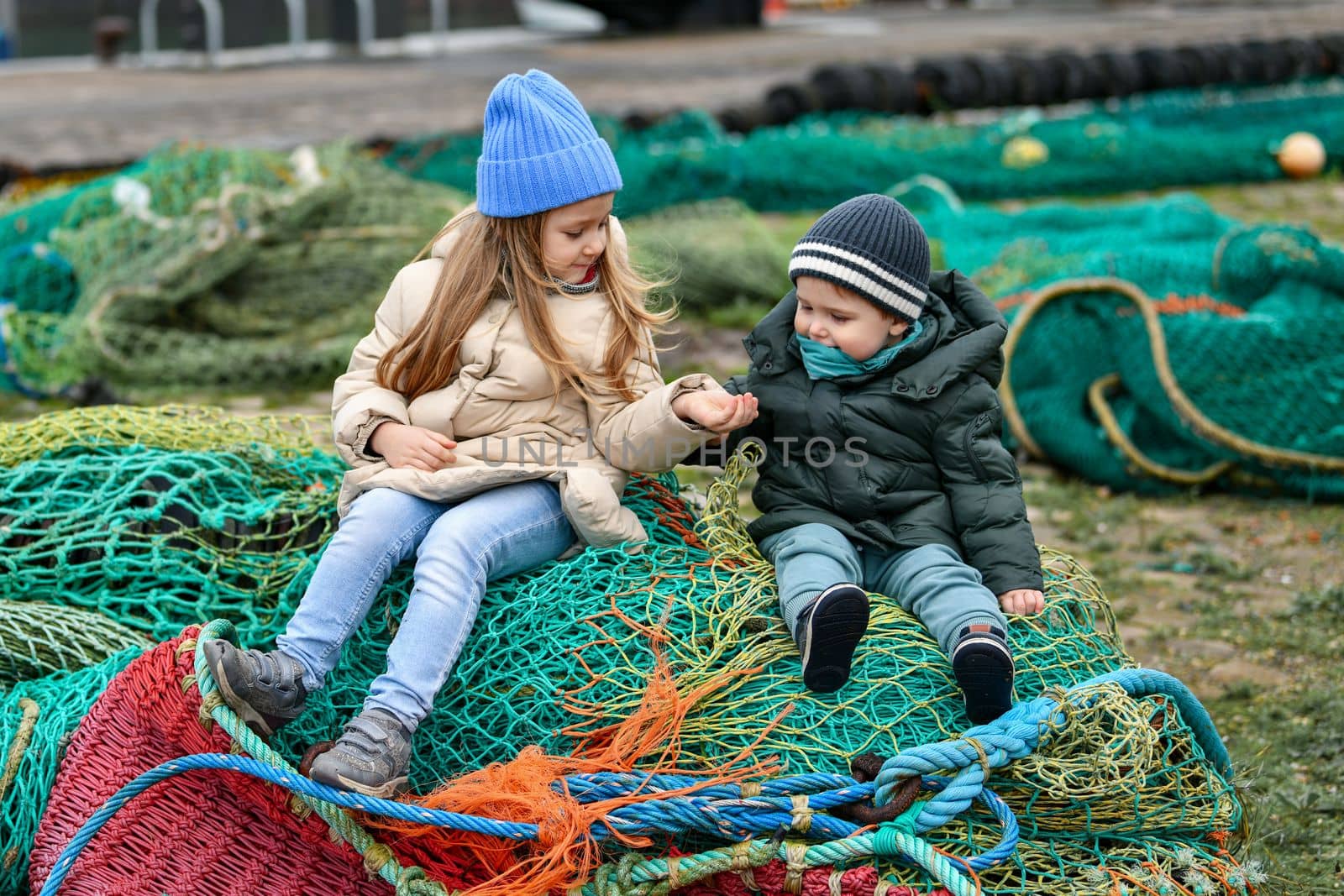 Brother and sister playing at the fishing nets