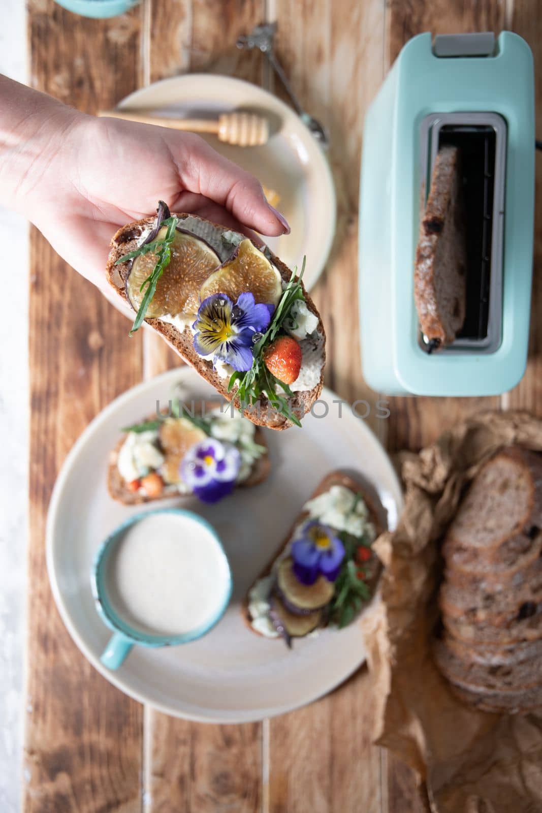 delicious bruschetta with homemade bread, garnished with fig,soft cheese,pansies, top view. High quality photo