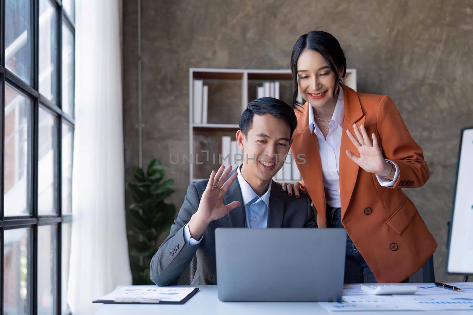 Asian business people having conference video call using laptop talking to coworker online audience sitting at office desk in office by nateemee