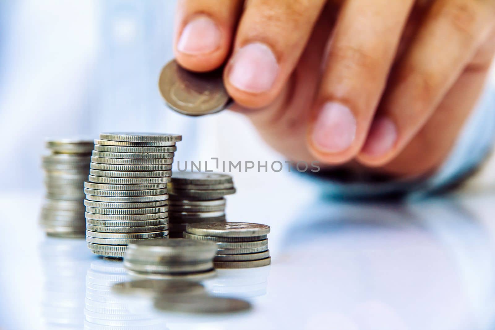 Hand put coin to stack, investment concept