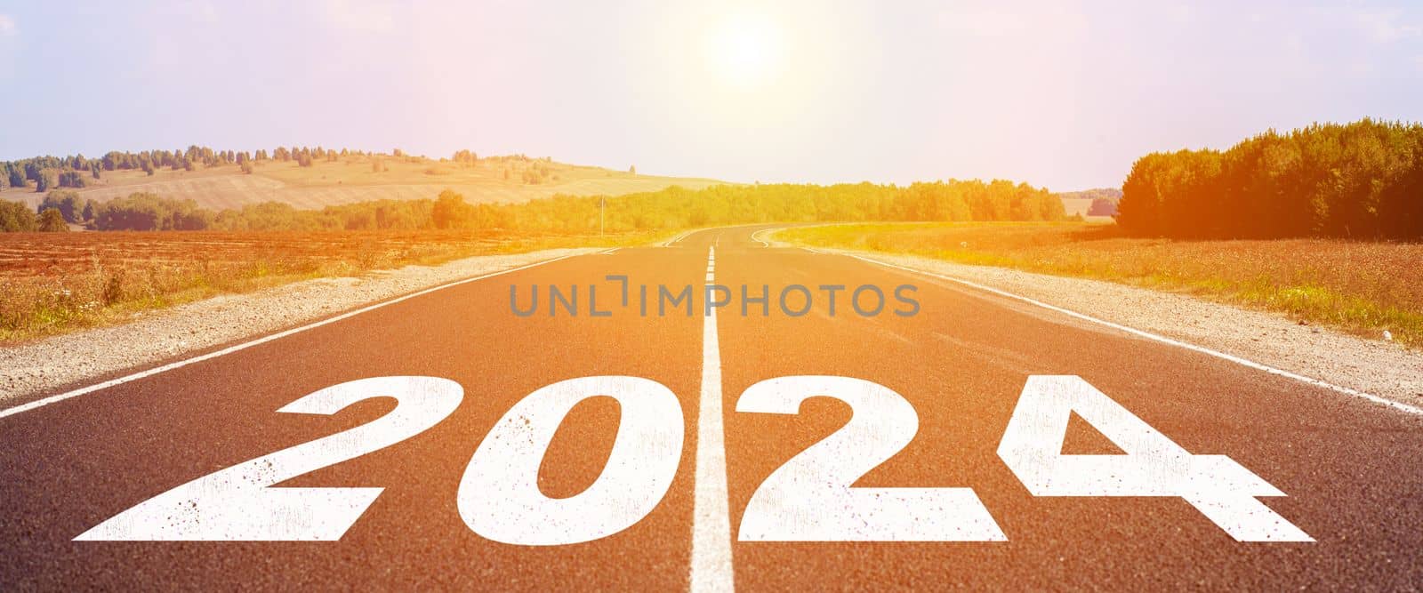 2024 written on highway road in the middle of empty asphalt road and beautiful blue sky. Concept for vision new year 2024.
