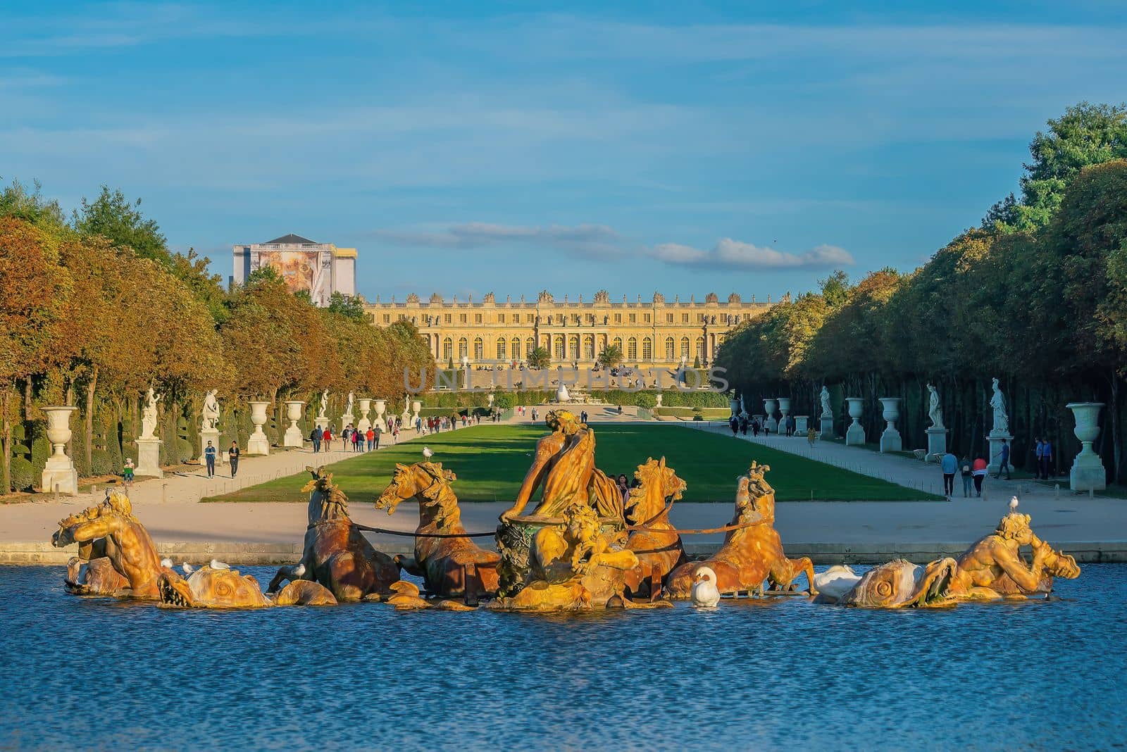 Garden of Chateau de Versailles and Apollo's fountain, near Paris in France at sunset