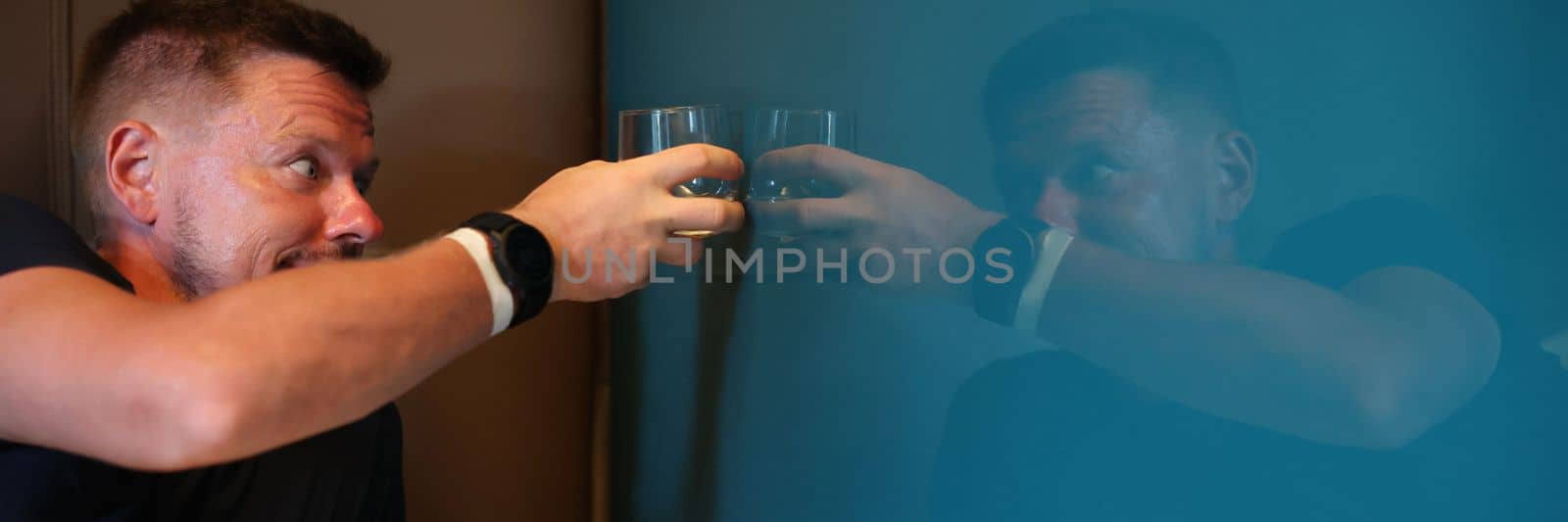 Man drinking whiskey with his reflection in mirror. Alcohol addiction concept