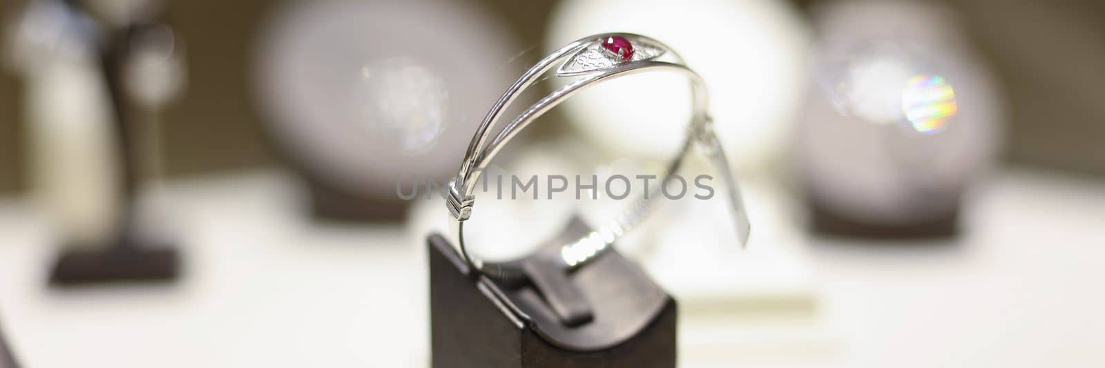 White gold ring with ruby on shop window closeup by kuprevich