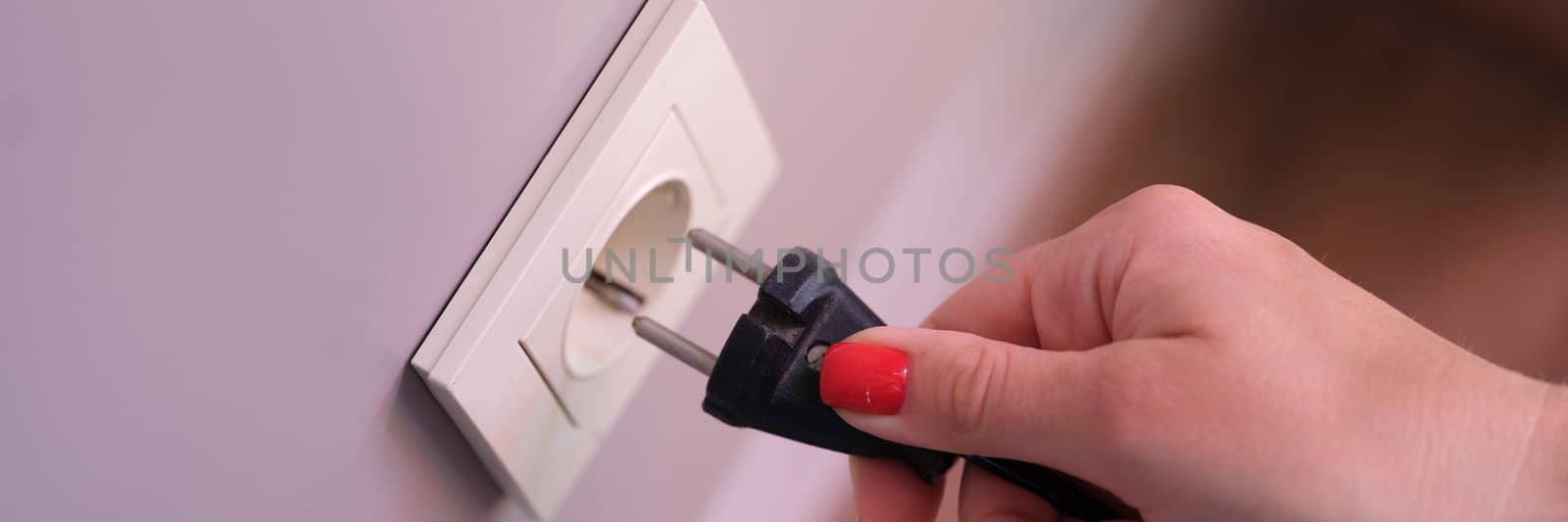 Hand inserts plug into socket closeup. Use of promising energy in home by kuprevich