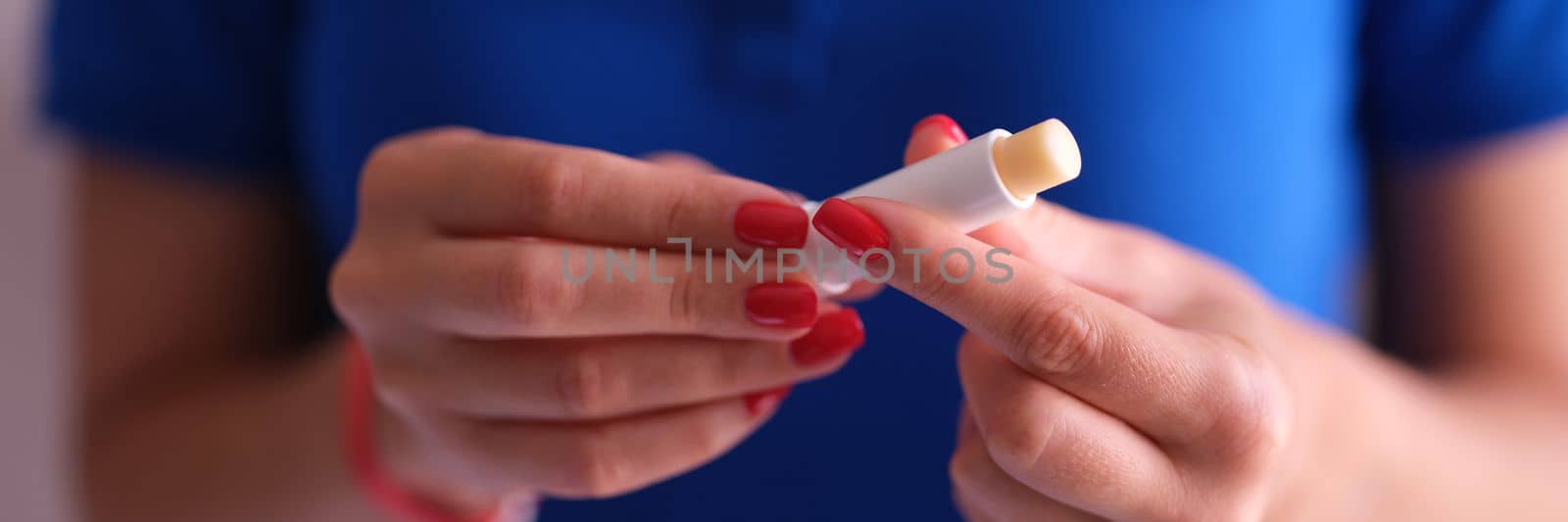 Woman with hygienic lipstick in hands closeup by kuprevich