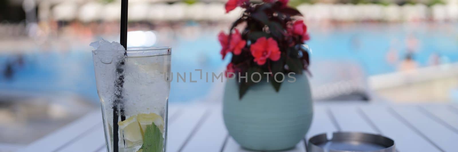 Lemonade and soft drinks in glass with ice. Summer cocktails drink on table by pool