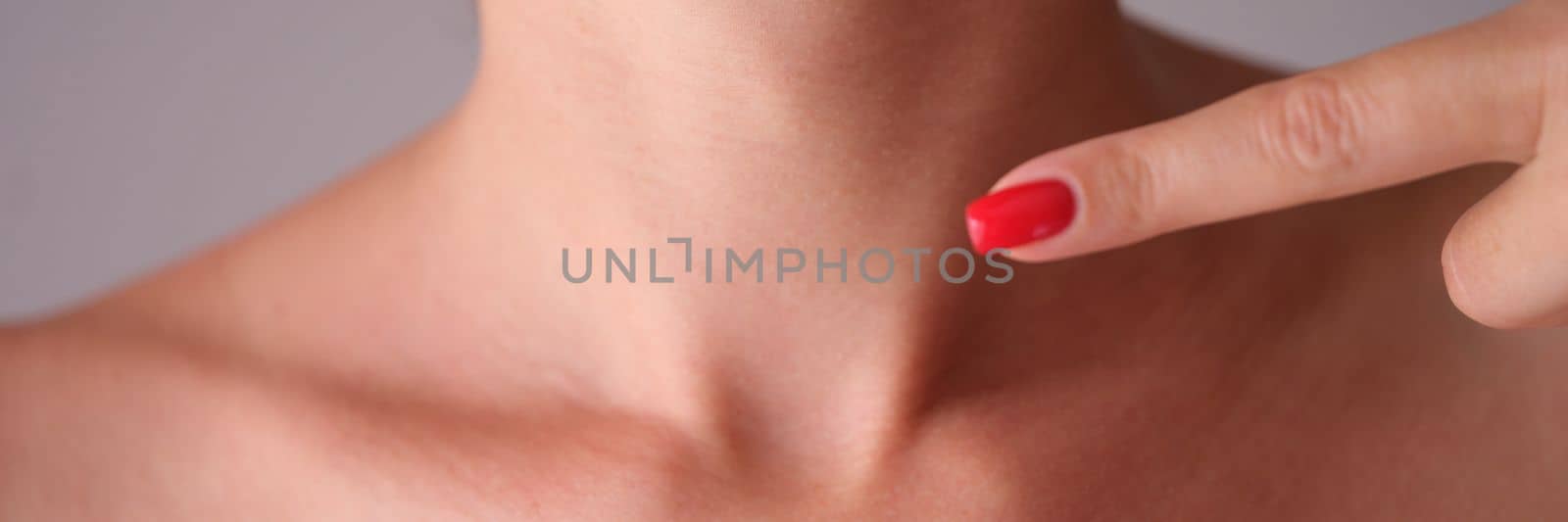 Woman manually checks thyroid gland in neck closeup by kuprevich