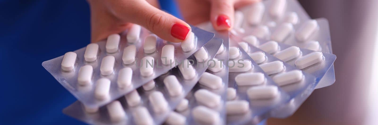 Woman hands hold lot of blisters with medical pills closeup. Taking medications and antidepressants concept