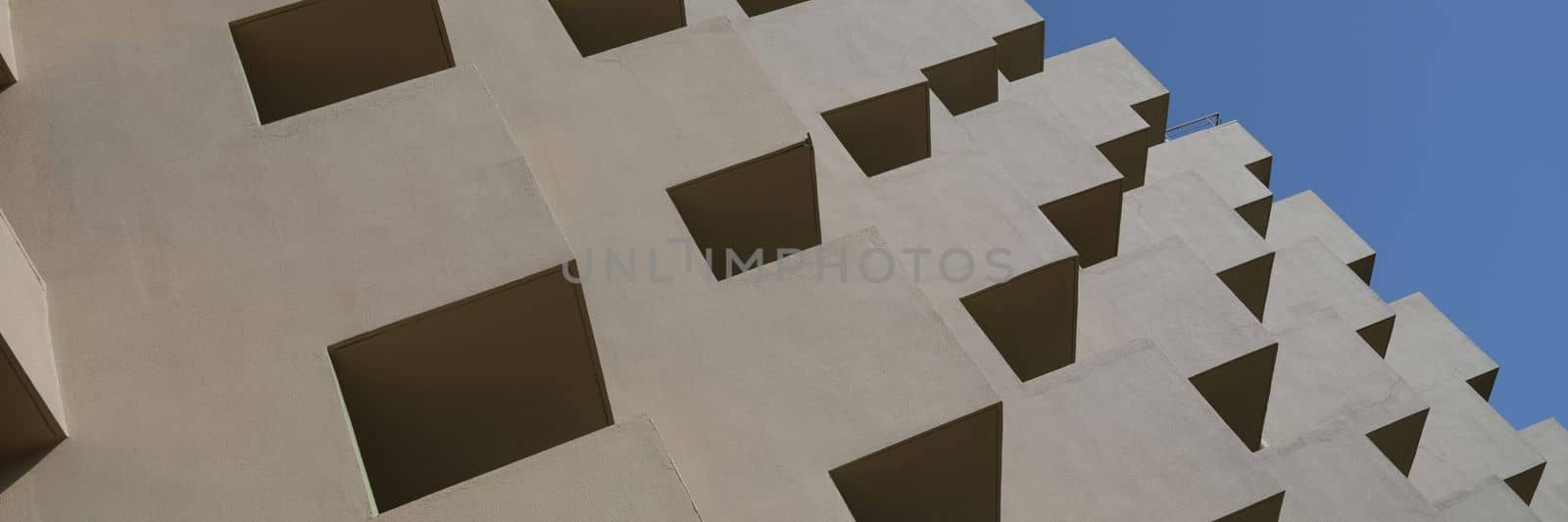 Modern facade of residential building with large balconies. View of modern concrete apartment building