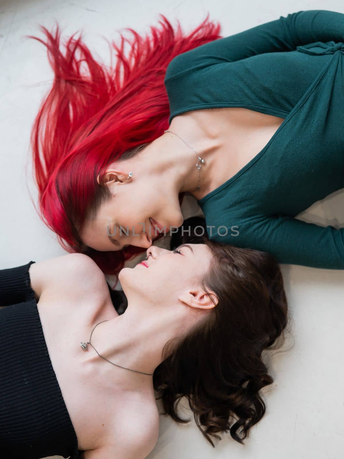 Top view of caucasian women lying and kissing. by mrwed54
