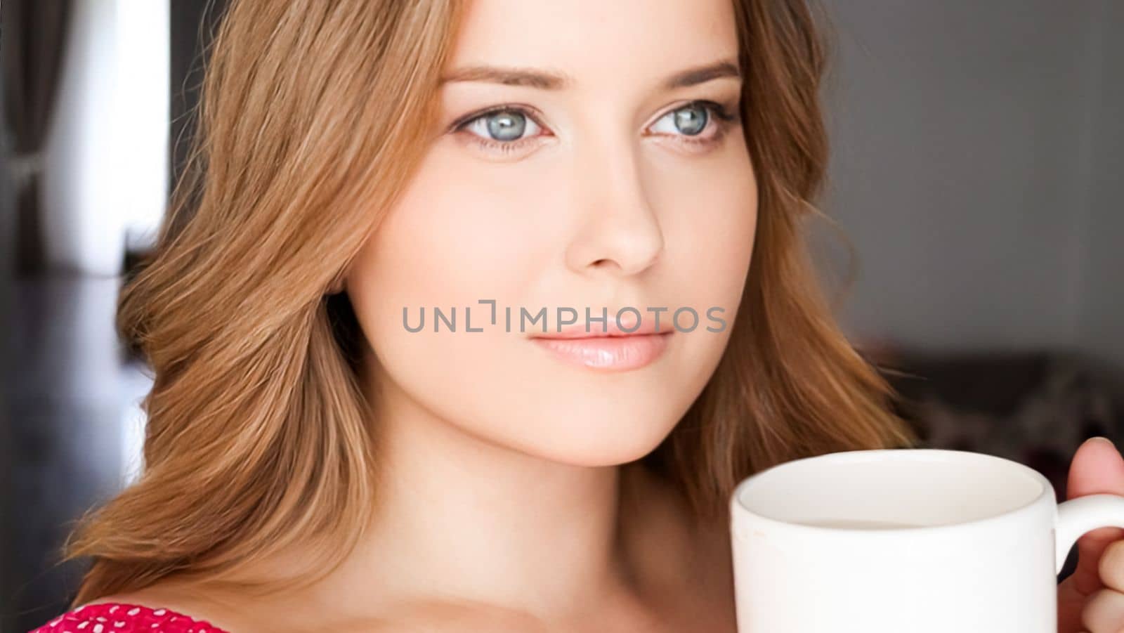 Beautiful woman having a cup of tea in the morning at home by Anneleven