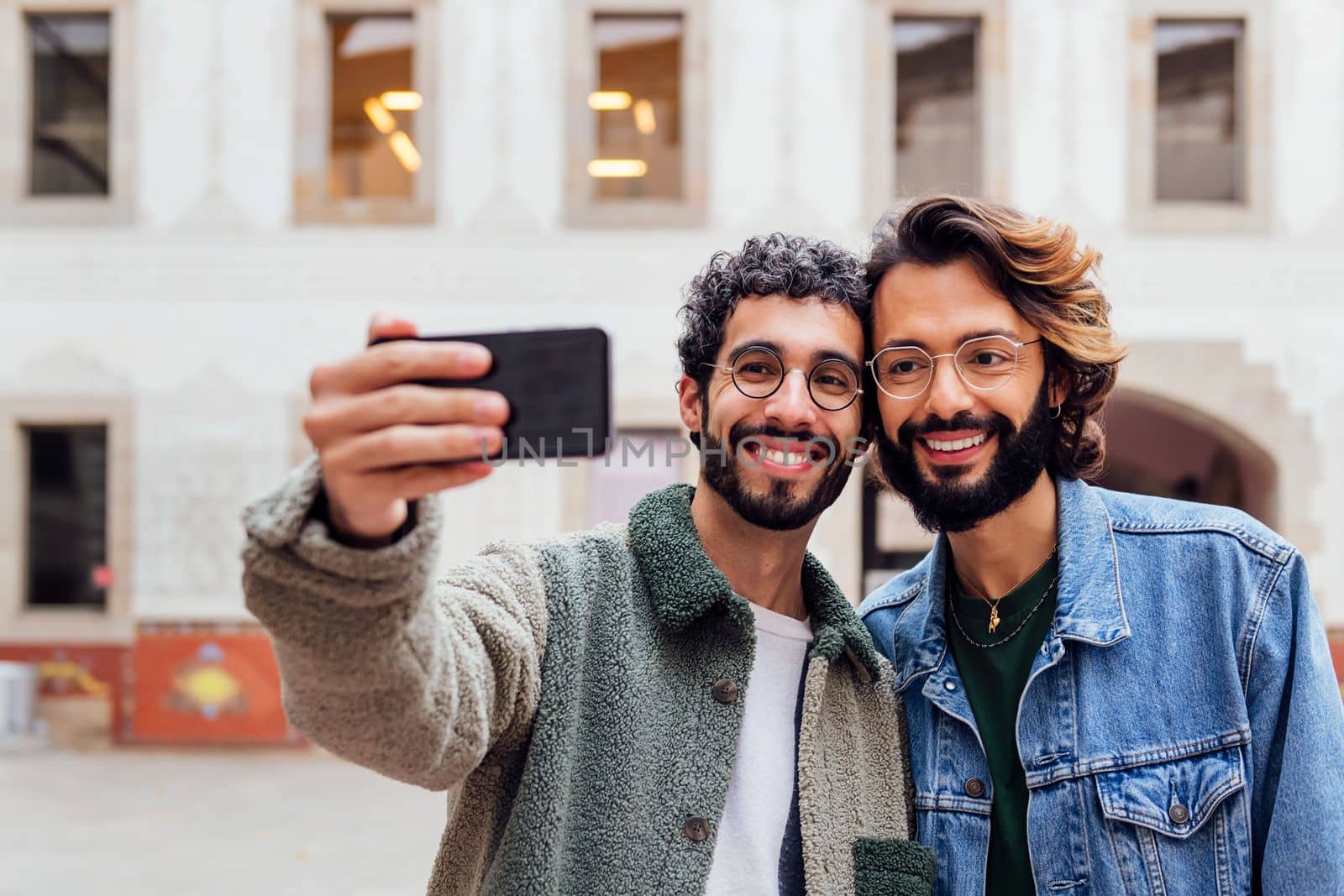 happy couple of gay men taking a selfie photo by raulmelldo