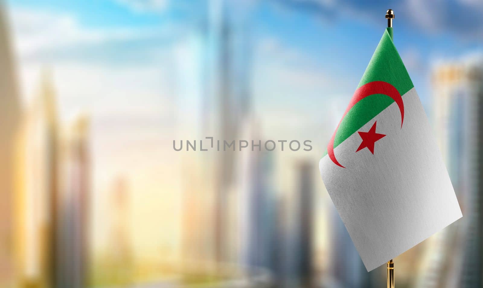 Small flags of the Algeria on an abstract blurry background by butenkow