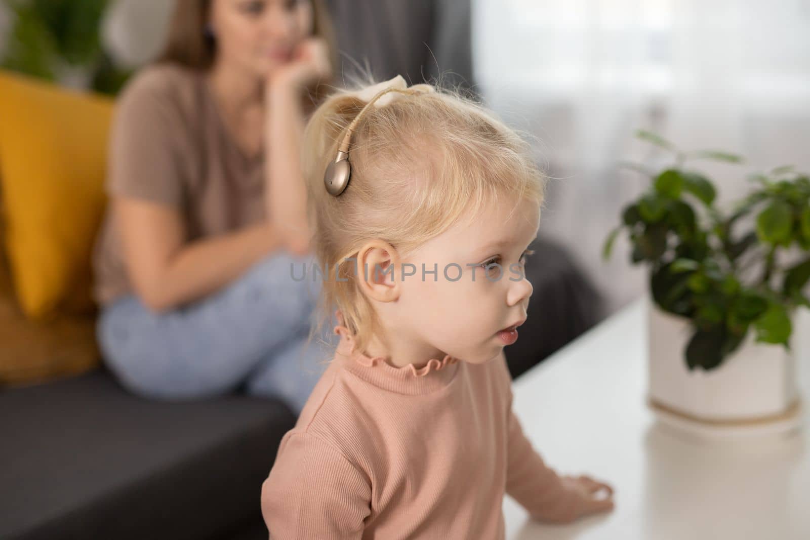 Cochlear implant system. Installation cochlear implant on child girl ear for restores hearing. Kid hears after hear return to normal.