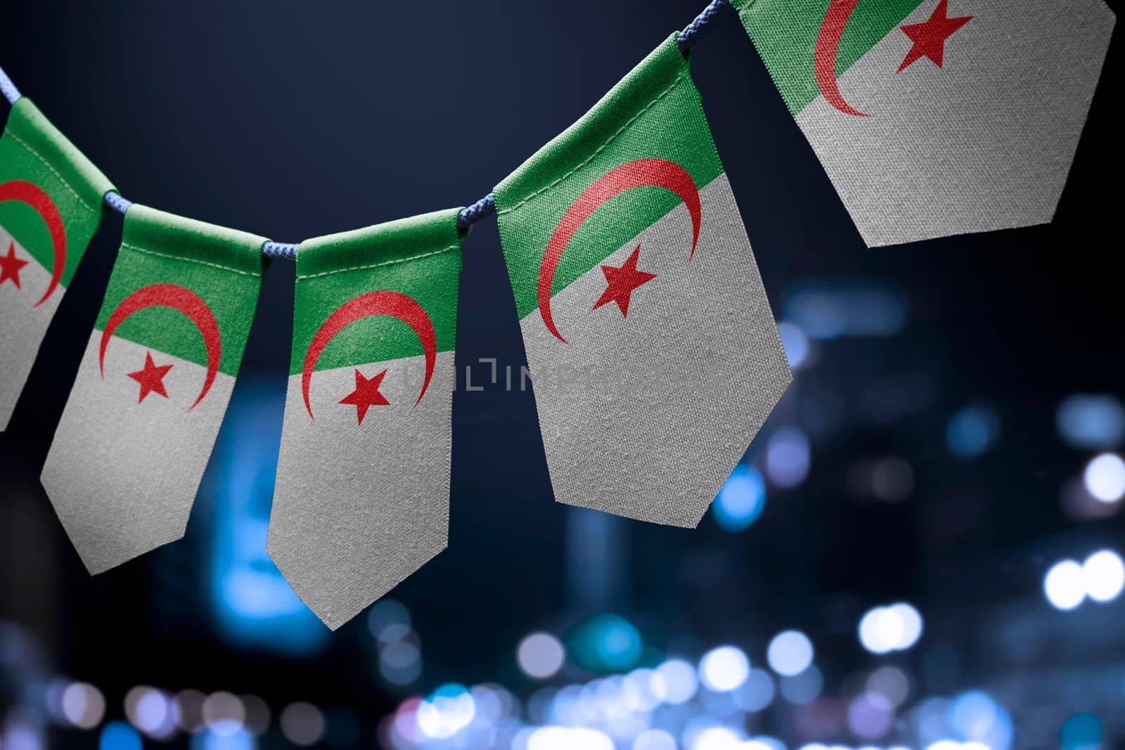 A garland of Algeria national flags on an abstract blurred background.