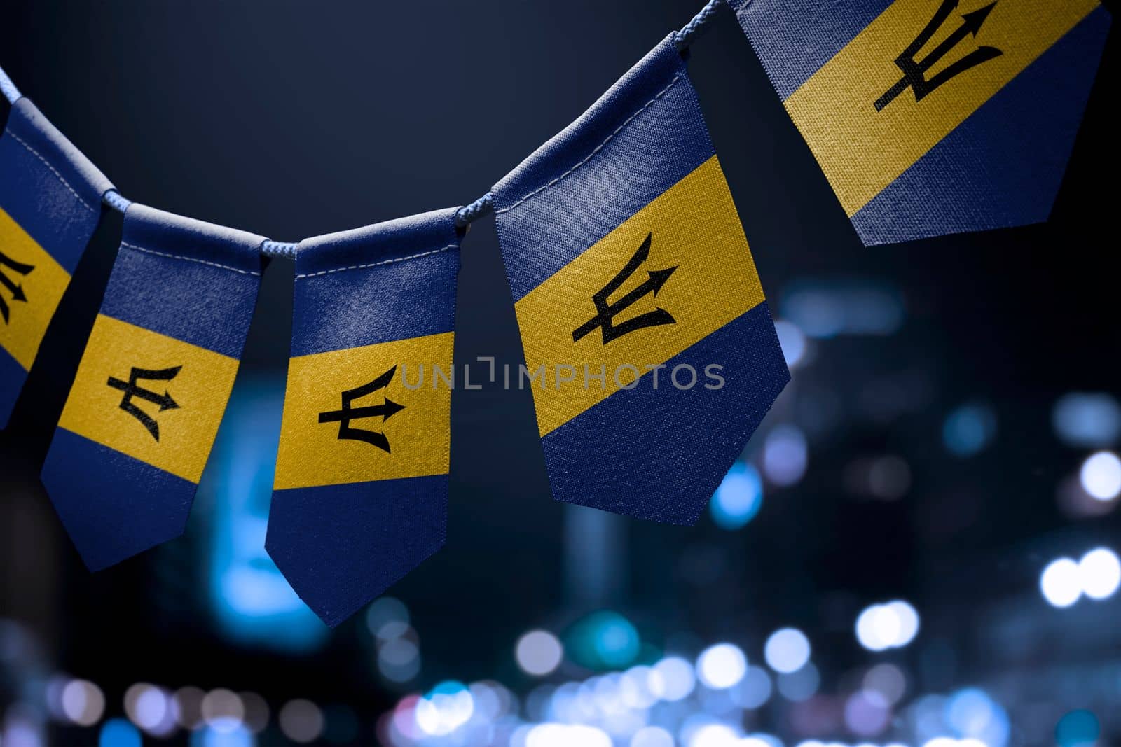 A garland of Barbados national flags on an abstract blurred background.