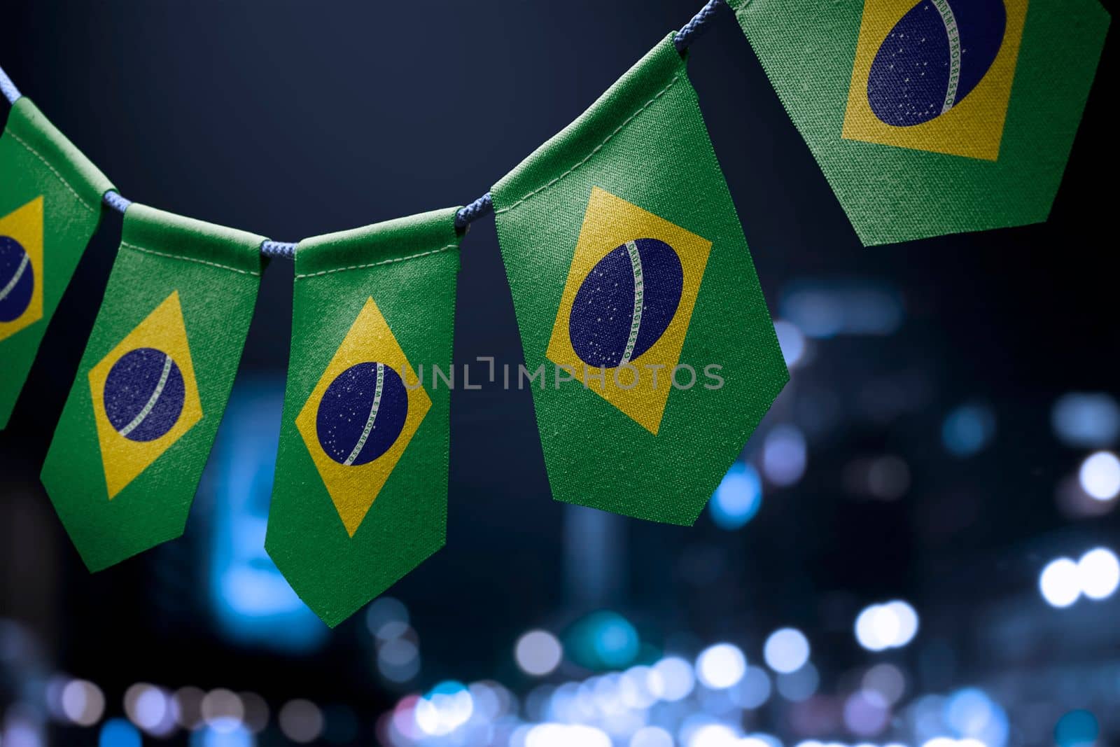 A garland of Brazil national flags on an abstract blurred background.
