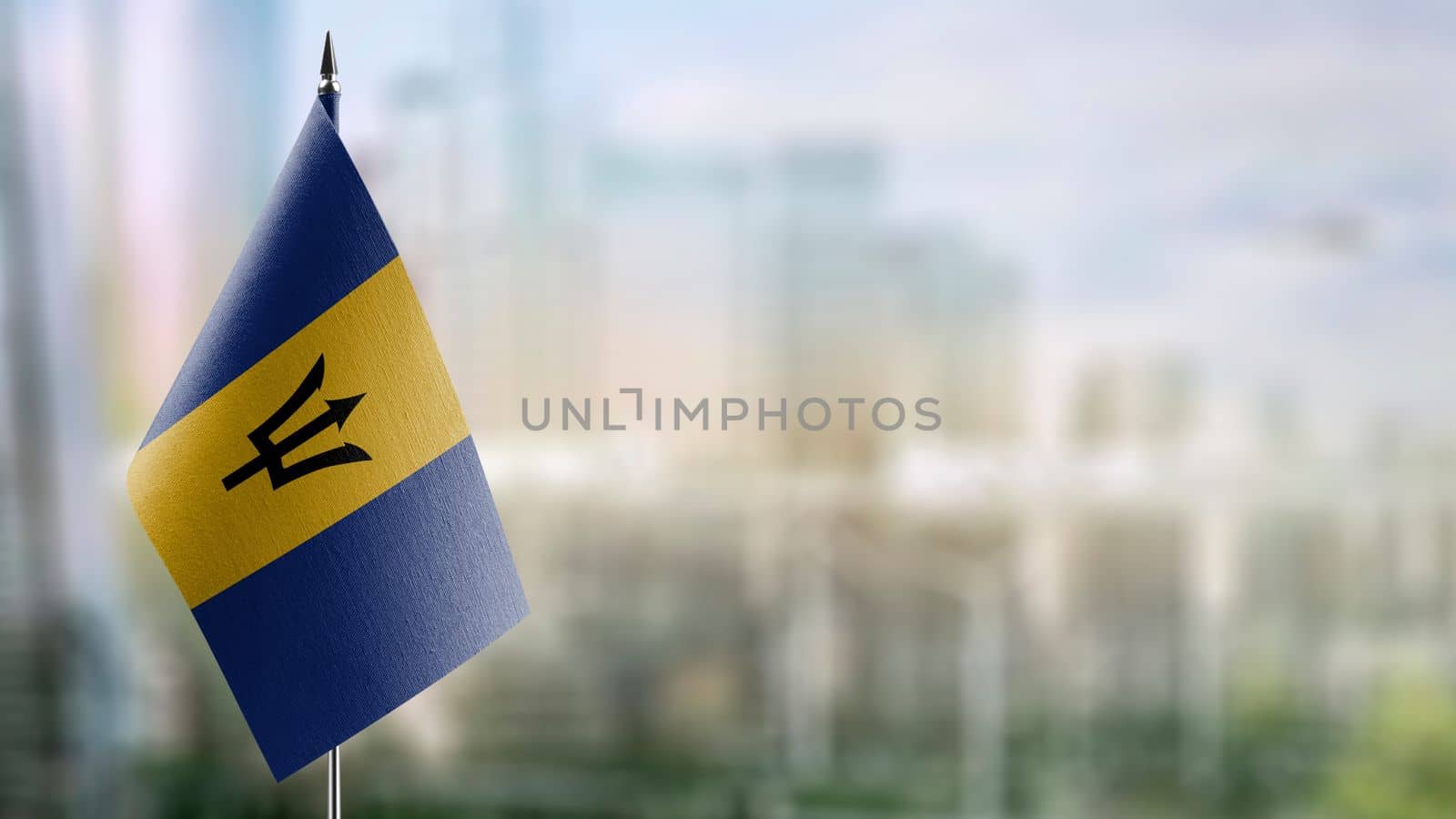 Small flags of the Barbados on an abstract blurry background.