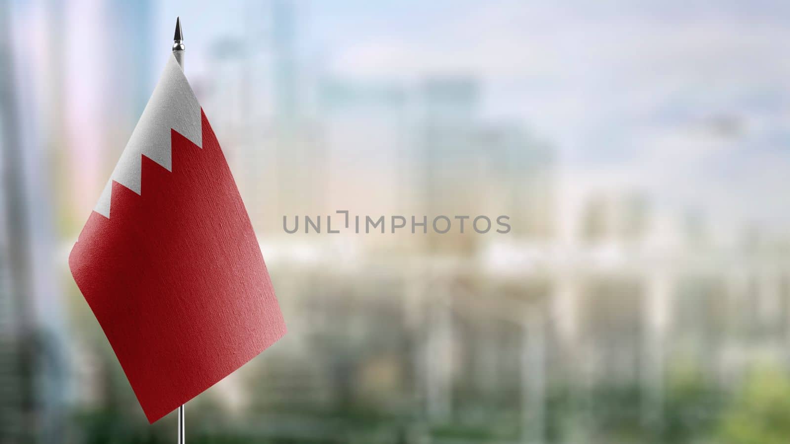 Small flags of the Bahrain on an abstract blurry background.