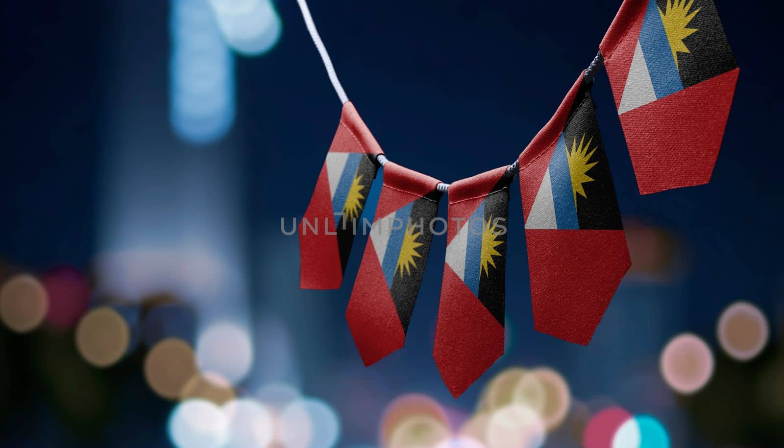 A garland of Antigua and Barbuda national flags on an abstract blurred background.