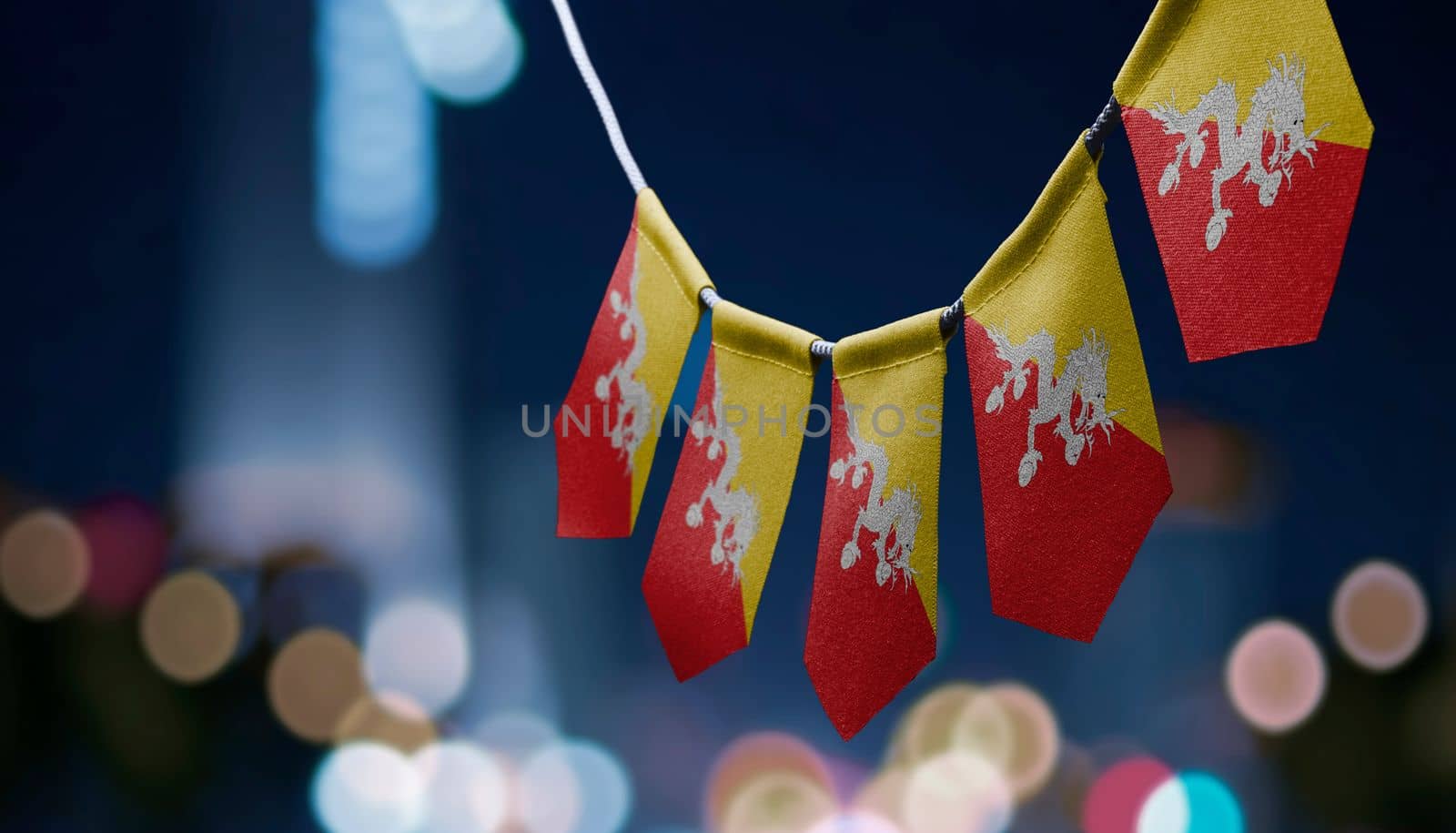 A garland of Bhutan national flags on an abstract blurred background by butenkow