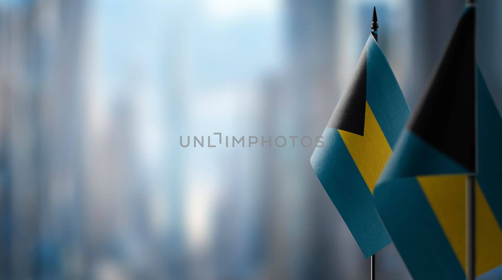 Small flags of the Bahamas on an abstract blurry background.
