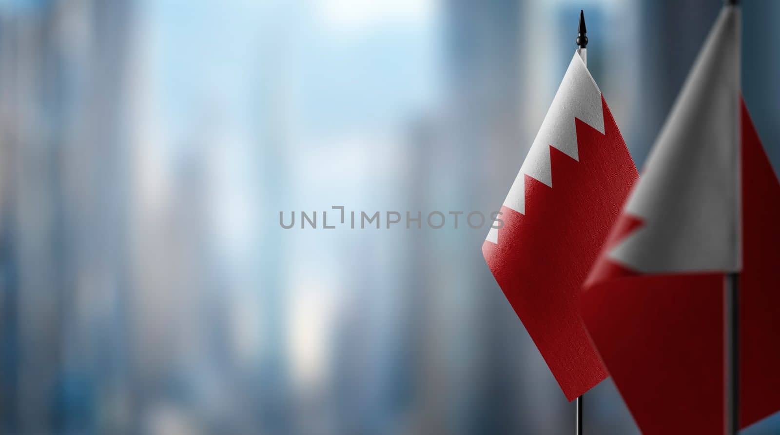 Small flags of the Bahrain on an abstract blurry background.