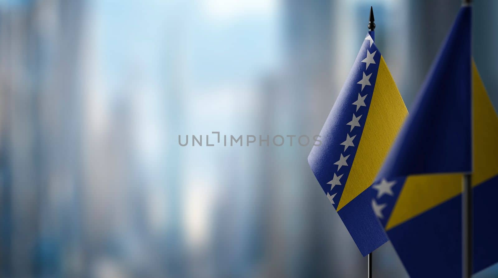 Small flags of the Bosnia and Herzegovina on an abstract blurry background by butenkow