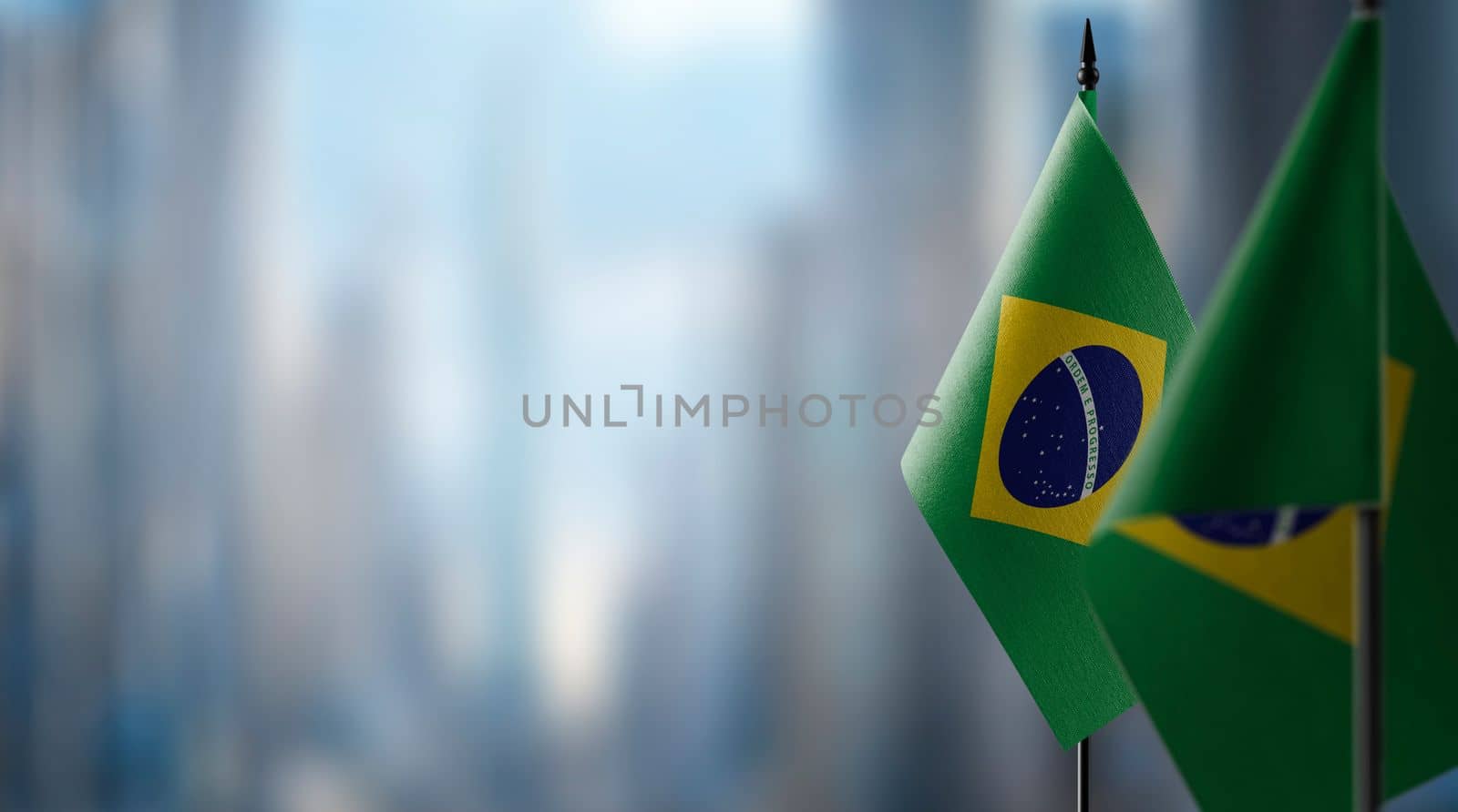 Small flags of the Brazil on an abstract blurry background.