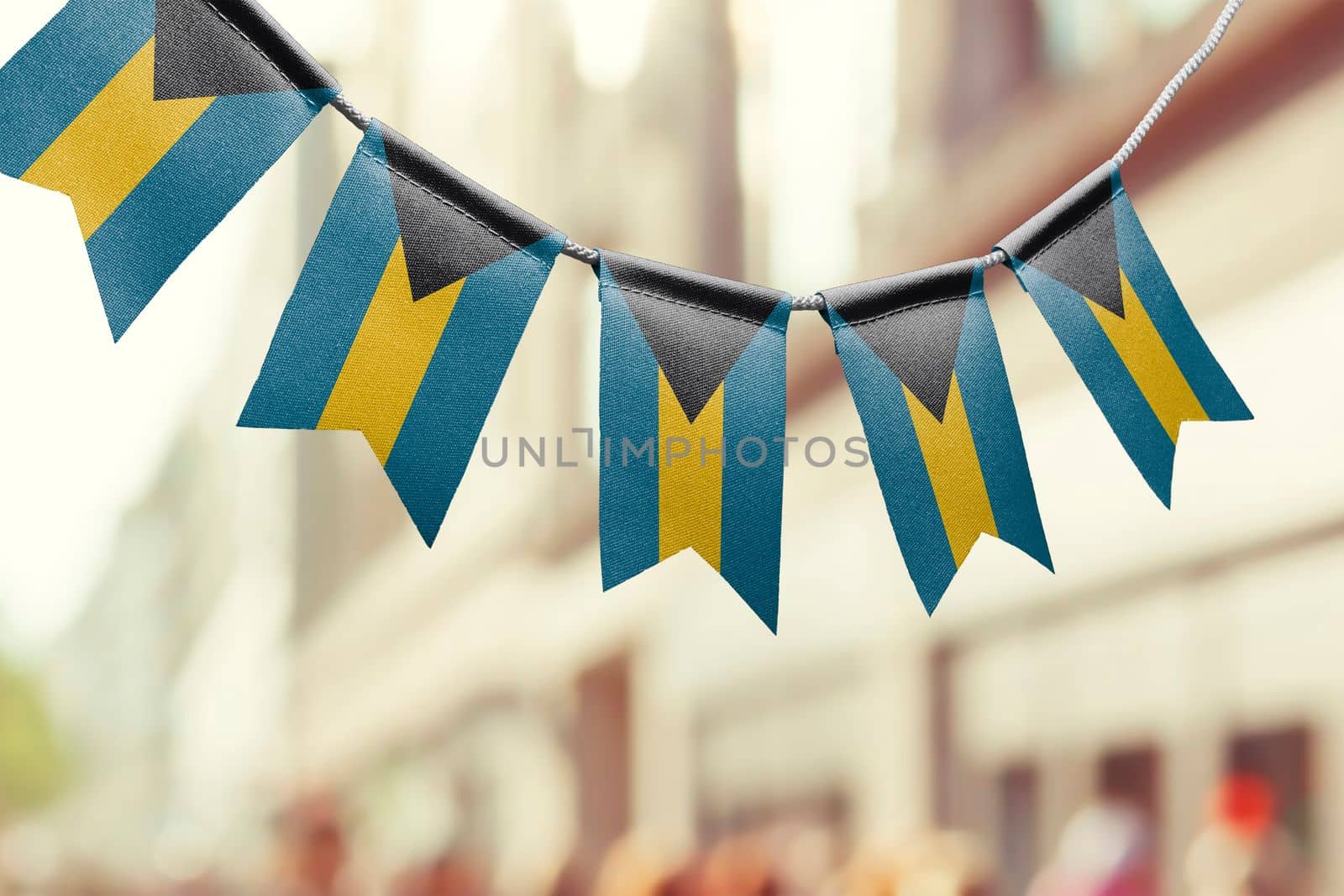 A garland of Bahamas national flags on an abstract blurred background.