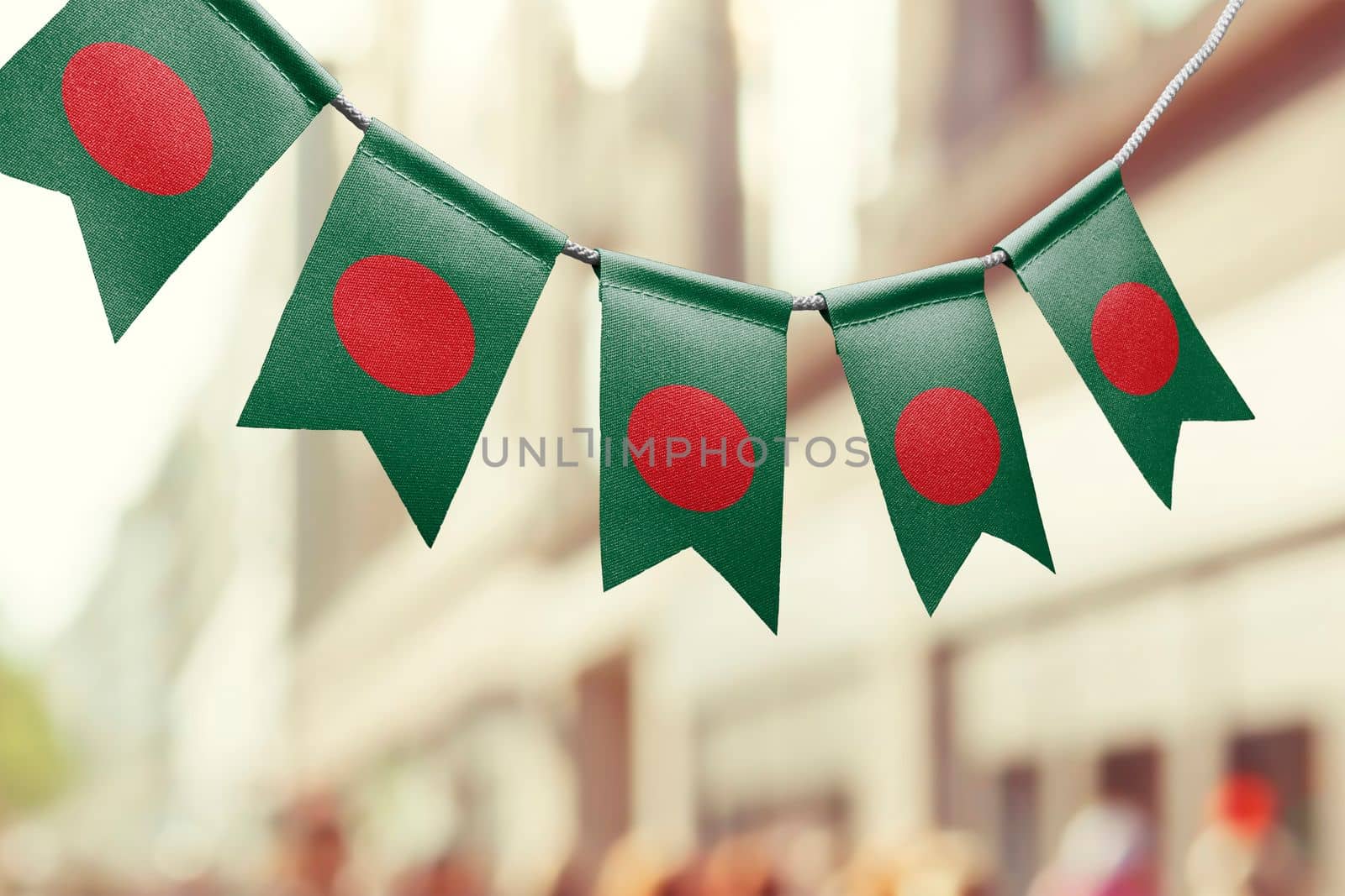 A garland of Bangladesh national flags on an abstract blurred background.