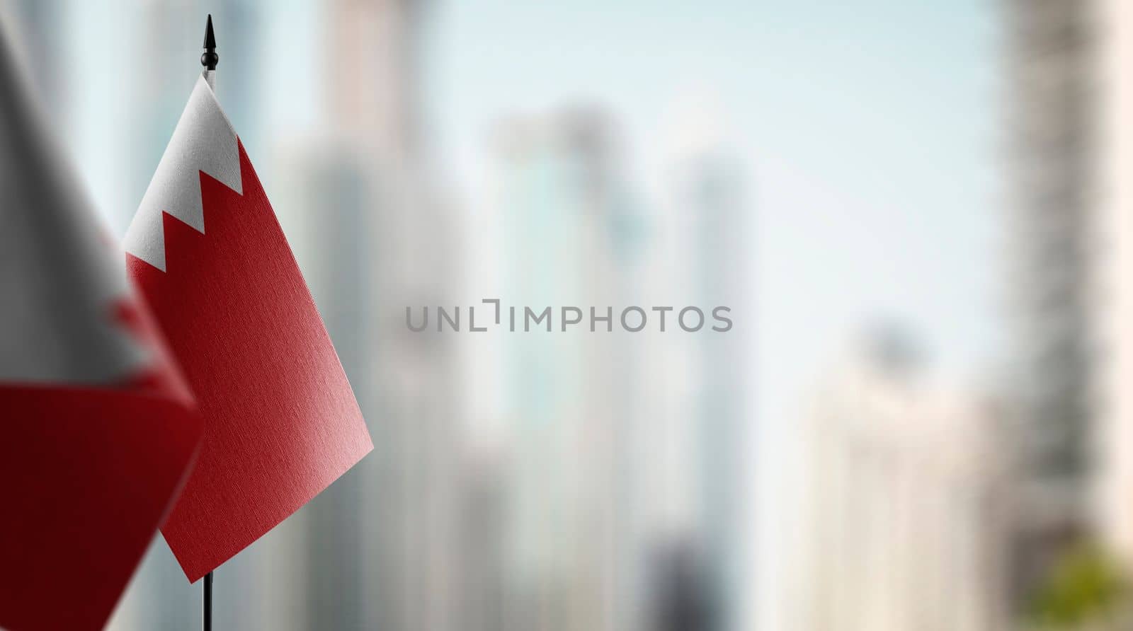 Small flags of the Bahrain on an abstract blurry background.