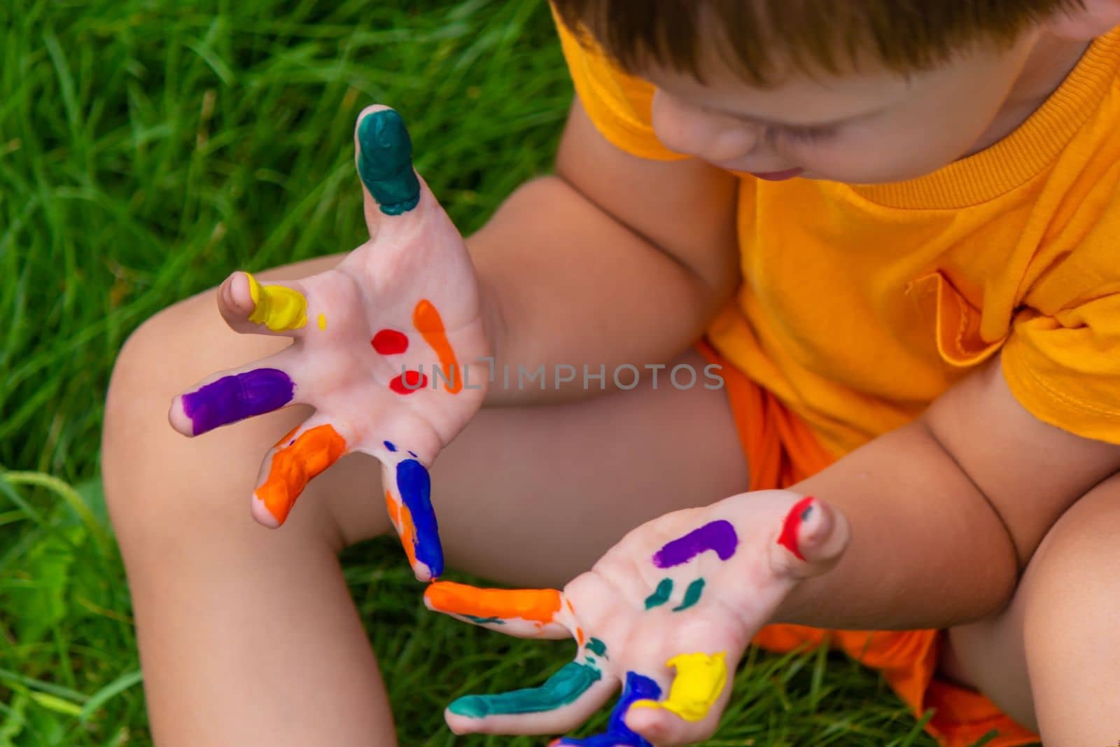 a smile painted with paints on the child's arms and legs. Selective focus