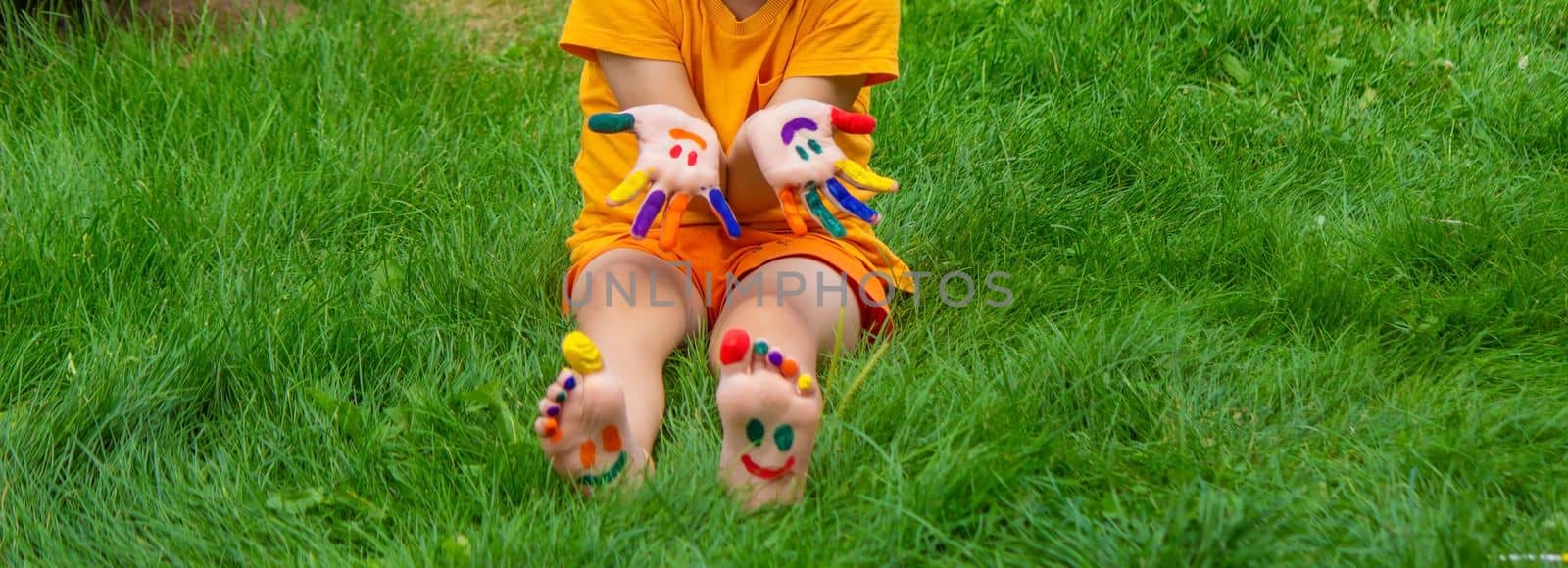 a smile painted with paints on the child's arms and legs. Selective focus