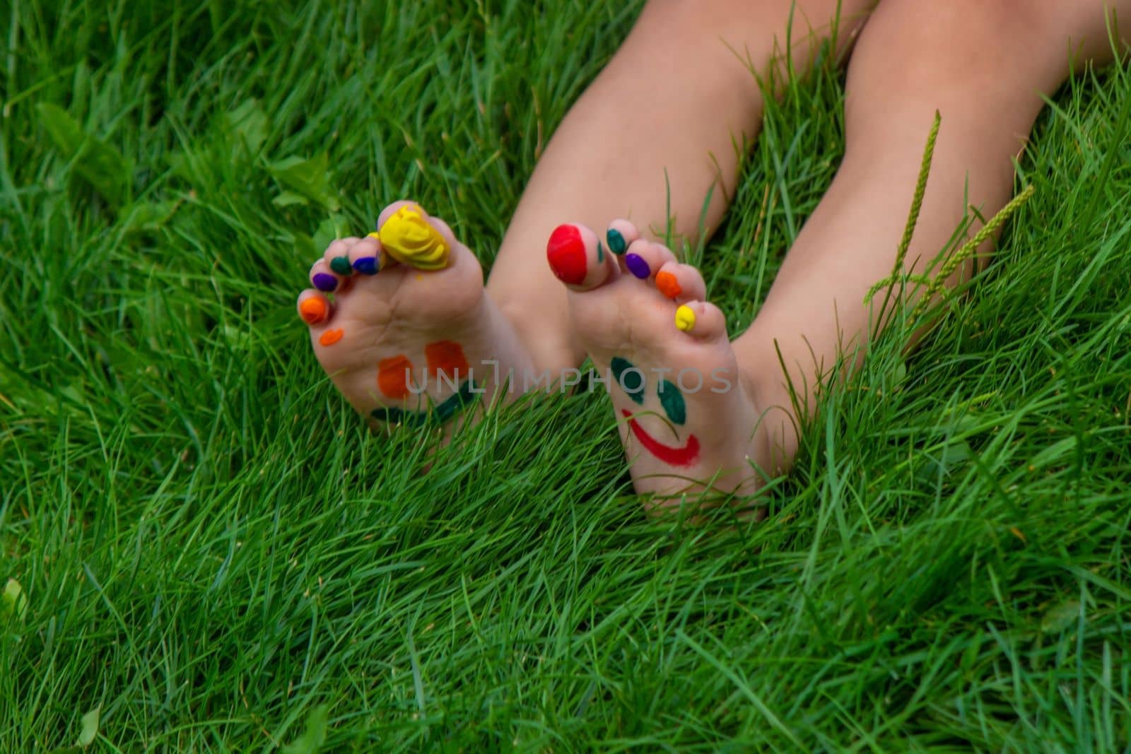 a smile painted with paints on the child's arms and legs. Selective focus