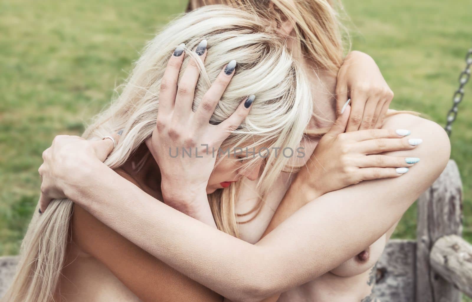 Intimate embrace between two young nude women, expressing love and passion. Romantic relationship in a tender and passionate moment.