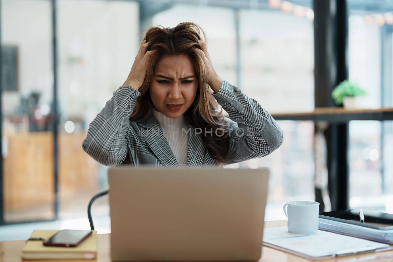 Portrait of business owner, woman using computer and financial statements Anxious expression on expanding the market to increase the ability to invest in business.