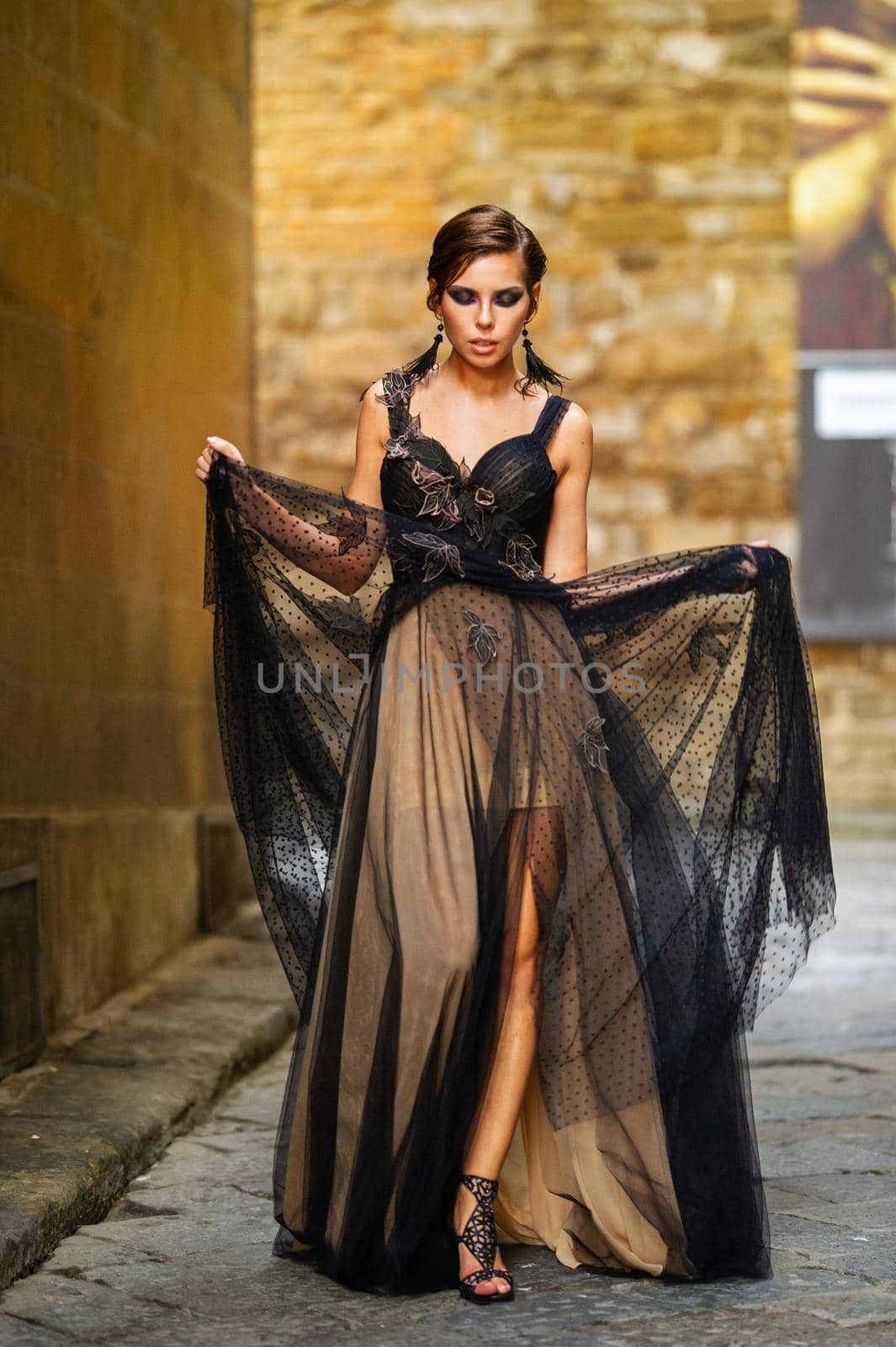 A beautiful stylish bride in a black dress walks through Florence, a Model in a black dress in the old city of Italy.