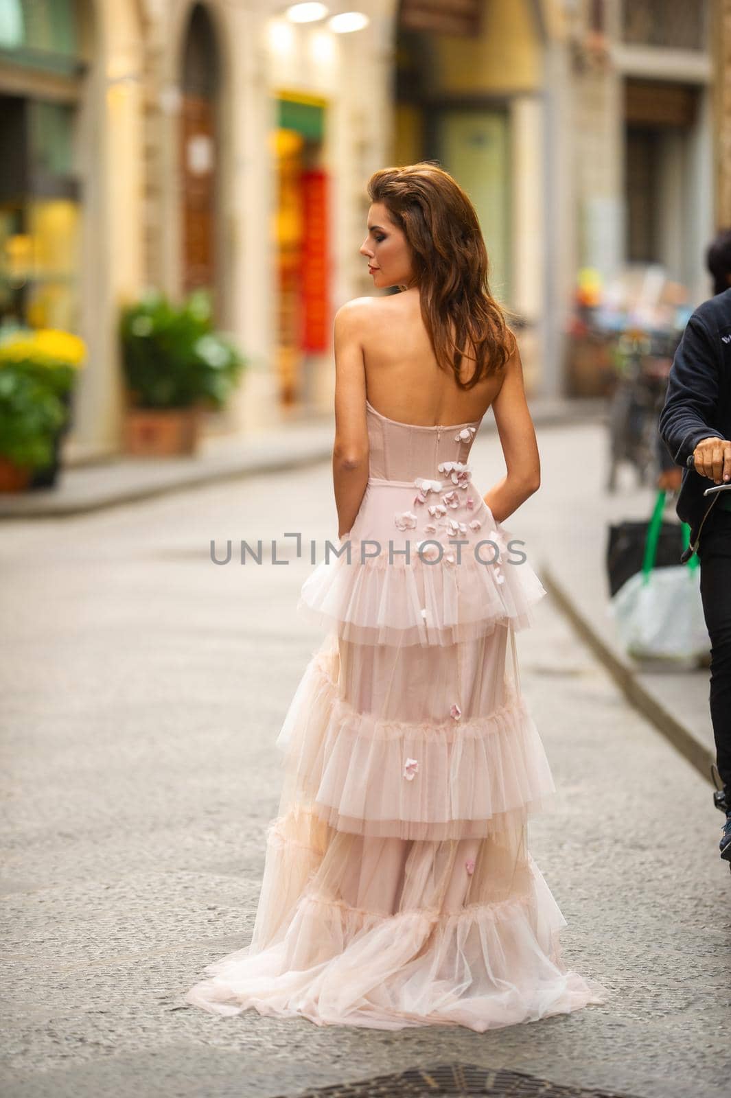 A bride in a pink wedding dress walks in Florence, Italy.