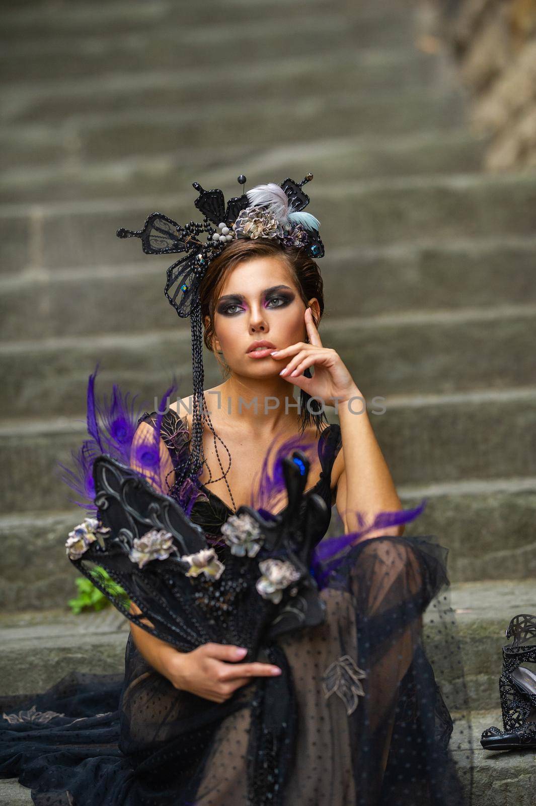 Beautiful stylish bride in a black dress sits on the stairs in Florence, Italy.