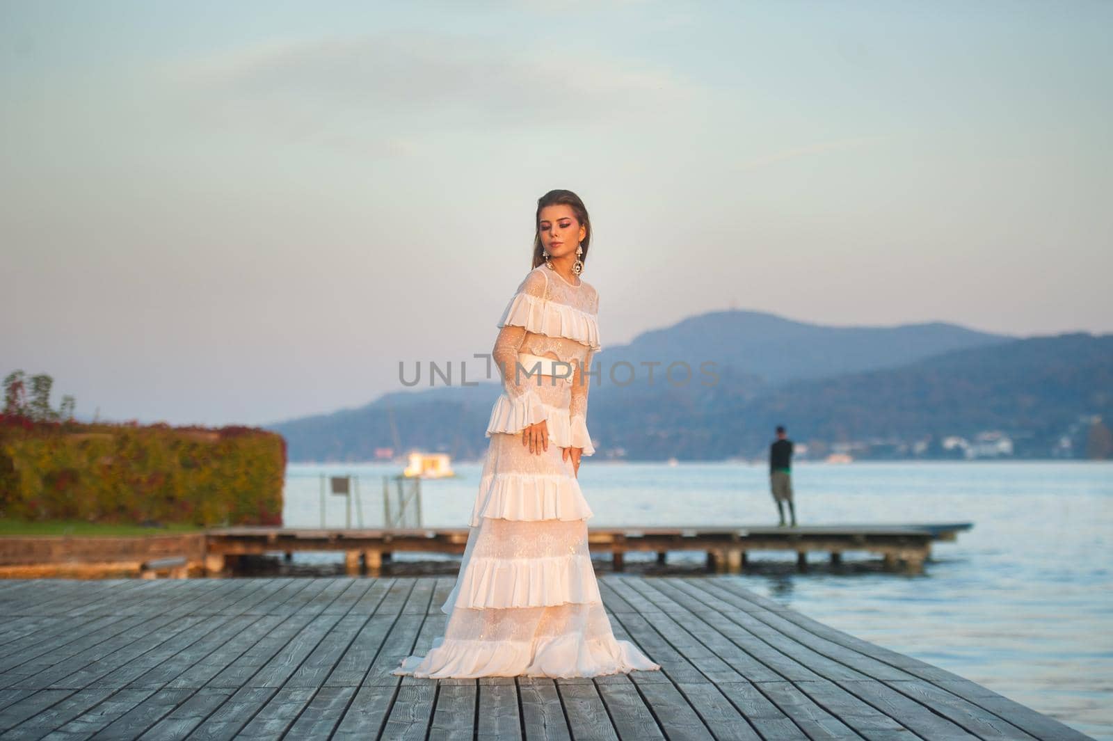 A bride in a white wedding dress in the old town of Austria at sunset.
